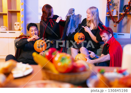 Dinner and group of people celebrating together at Halloween party. Dinner and group of people celebrating together at Halloween party. 130845198