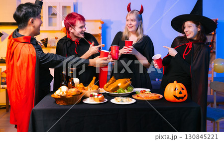 Dinner and group of people celebrating together at Halloween party. 130845221
