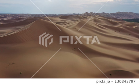 Aerial view of sand dunes in desert at sunset 130845797