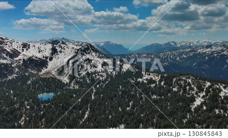 Rocky mountains in snow and green fir forest Rocky mountains in snow and green fir forest 130845843