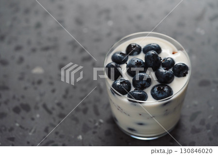 greek yogurt with blueberries and granola in glass on concrete background 130846020