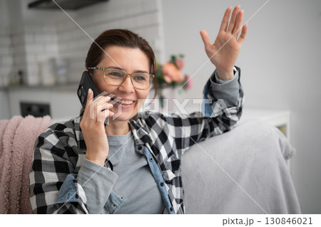 Woman Talking On The Phone Smiles Joyfully At Home 130846021