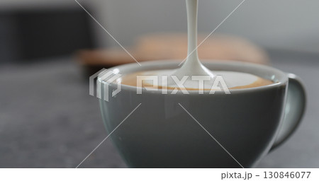 Steamed milk pour into coffee making cappuccino 130846077