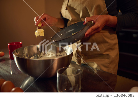 Woman Preparing Dough for Baking in a Warm, Inviting Kitchen Setting 130846095