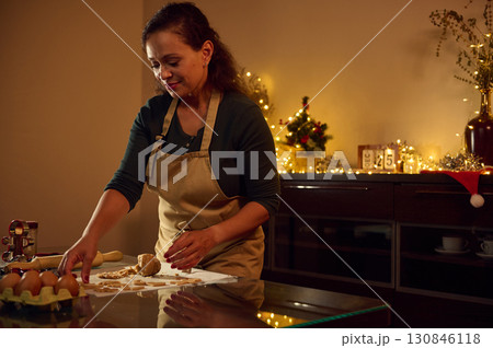 Woman Preparing Gingerbread Cookies in a Festive Christmas Kitchen Setup Woman Preparing Gingerbread Cookies in a Festive Christmas Kitchen Setup 130846118