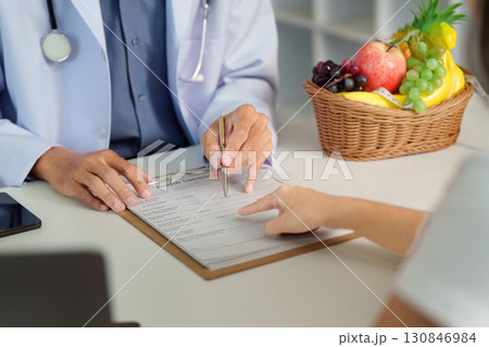 Nutrition Consultation. Doctor discussing health summary with patient, emphasizing healthy eating. Nutrition Consultation. Doctor discussing health summary with patient, emphasizing healthy eating. 130846984