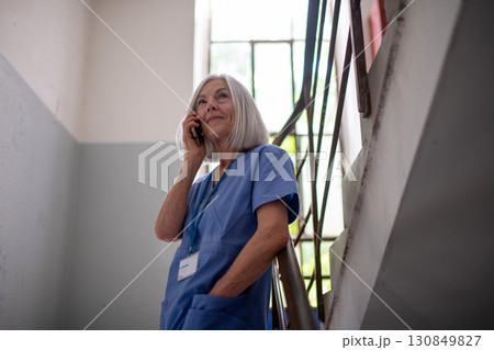 Tired nurse taking break during hospital shift, calling with family. Tired nurse taking break during hospital shift, calling with family. 130849827