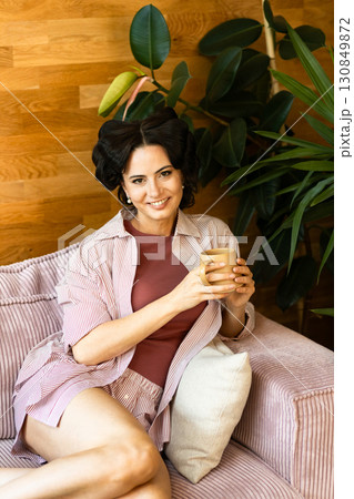 Portrait of woman with hair rollers during slow morning. 130849872