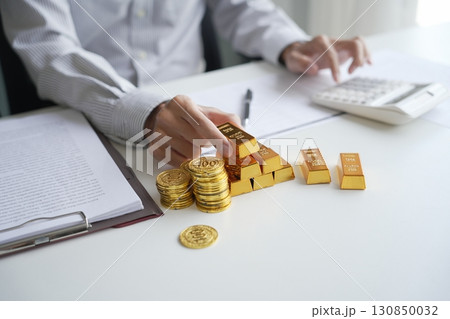 Gold Trading Businessman invest in trading gold on the stock exchange price rising. 130850032