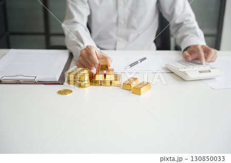Gold Trading Businessman invest in trading gold on the stock exchange price rising. Gold Trading Businessman invest in trading gold on the stock exchange price rising. 130850033