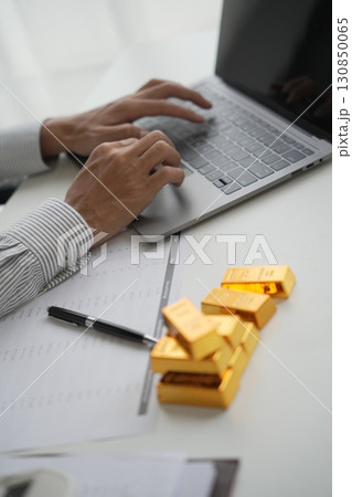 Gold Trading Businessman invest in trading gold on the stock exchange price rising. Gold Trading Businessman invest in trading gold on the stock exchange price rising. 130850065