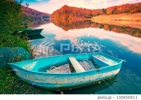Lakeshore with boat in autumn. View of the lake with reflection Lakeshore with boat in autumn. View of the lake with reflection 130850811