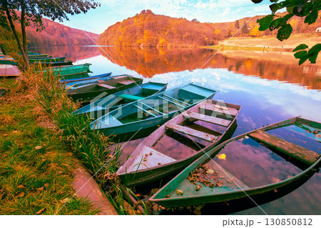 Lakeshore with boats in autumn. View of the lake with reflection Lakeshore with boats in autumn. View of the lake with reflection 130850812