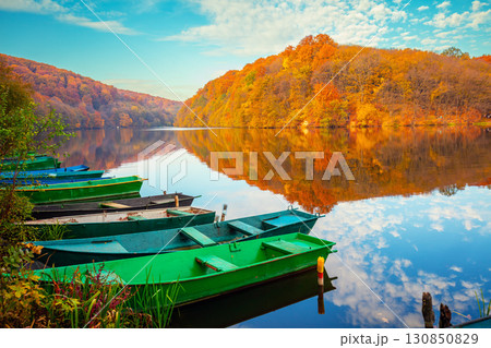 Lakeshore with boats in autumn. View of the lake with reflection 130850829