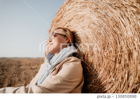 Relaxing Against a Hay Bale on a Sunny Day 130850890