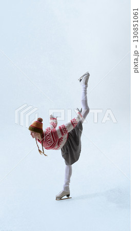 Female skater in traditional knit sweater balancing on ice in winter style Female skater in traditional knit sweater balancing on ice in winter style 130851061