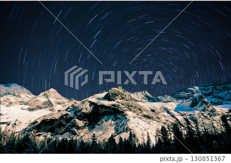 night view of snowy mountain range and milky way. starry night sky with stars and moon. beautiful landscape with snowy mountain peaks in winter night. night view of snowy mountain range and milky way. starry night sky with stars and moon. beautiful landscape with snowy mountain peaks in winter night. 130851367