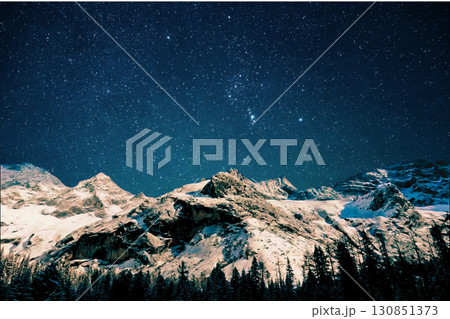 night view of snowy mountain range and milky way. starry night sky with stars and moon. beautiful landscape with snowy mountain peaks in winter night. night view of snowy mountain range and milky way. starry night sky with stars and moon. beautiful landscape with snowy mountain peaks in winter night. 130851373
