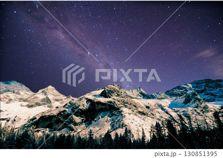 night view of snowy mountain range and milky way. starry night sky with stars and moon. beautiful landscape with snowy mountain peaks in winter night. night view of snowy mountain range and milky way. starry night sky with stars and moon. beautiful landscape with snowy mountain peaks in winter night. 130851395