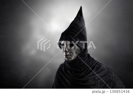 Portrait of a ghostly figure with long hat over dark misty background Portrait of a ghostly figure with long hat over dark misty background 130851416