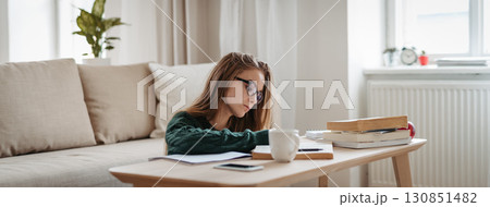 Young female student sitting on floor and studying. Young female student sitting on floor and studying. 130851482