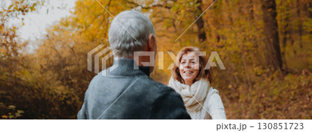 Hugging older couple spending time outdoors in fall season. Hugging older couple spending time outdoors in fall season. 130851723