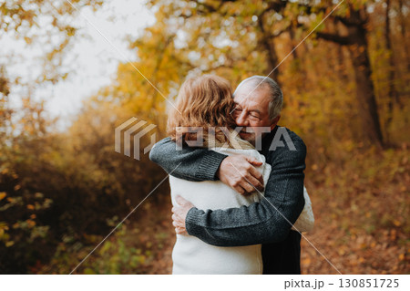 Romantic walk through fall forest by senior couple. Romantic walk through fall forest by senior couple. 130851725