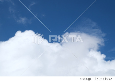 clear blue sky with a few clouds. The sky is very bright and the clouds are scattered throughout 130851952