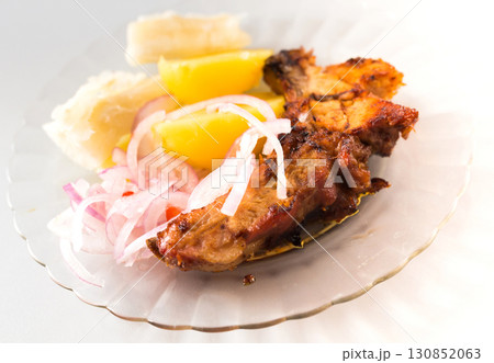 dish of fried pork ribs, rice, potatoes, sweet potato and pickled onions 130852063