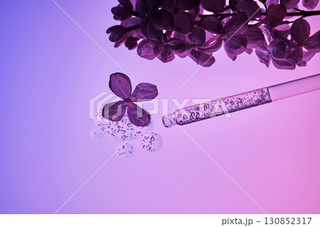 Cosmetic pipette with serum and lilac flowers. 130852317