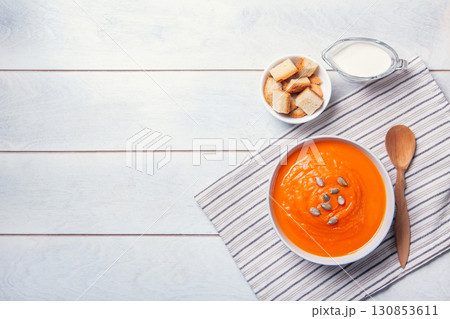 Pumpkin soup-puree with breadcrumbs, cream and seeds on a white wooden background. Copy space Pumpkin soup-puree with breadcrumbs, cream and seeds on a white wooden background. Copy space 130853611
