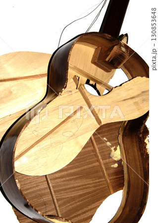 A broken smashed acousitic guitar music instrument on white background 130853648