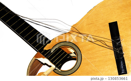 A broken smashed acousitic guitar music instrument on white background 130853661