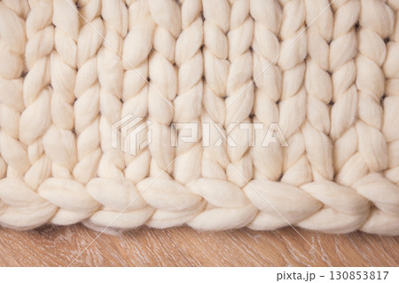 Blanket of thick yarn or merino wool plaid on floor. Background flat lay with copyspace Blanket of thick yarn or merino wool plaid on floor. Background flat lay with copyspace 130853817