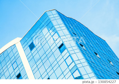 Part of the building with glazed windows against the sky 130854227