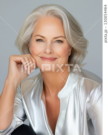 Elegant older woman with silver hair posing thoughtfully against a plain background Elegant older woman with silver hair posing thoughtfully against a plain background 130854464