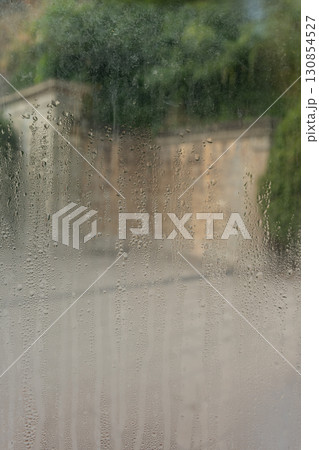 Closeup shot of a steamy window with water drops 130854527