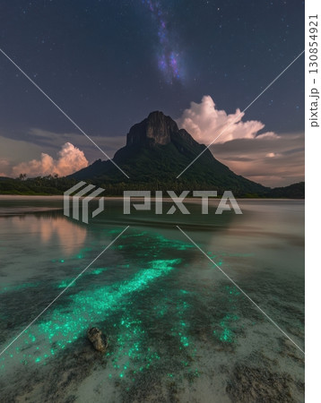 Night Sky Tropical Island Mountain Beach Bioluminescent Ocean sea dark blue glow sand calm dark rock 130854921