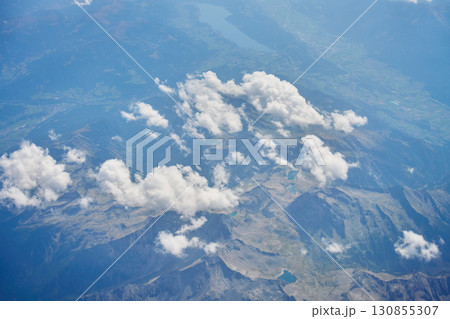 Aerial view of mountains and clouds from airplane window 130855307