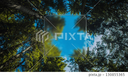 Futuristic glass frame floating in forest sky perspective with blurred digital effect 130855365