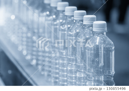 The empty drinking water bottles on the conveyor belt for filling process in the blue scene. The empty drinking water bottles on the conveyor belt for filling process in the blue scene. 130855496