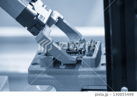 Close up scene the micro circuit board assembly process by robotic arm in the light blue scene. 130855499