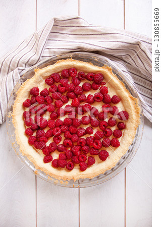 Preparation of shortbread pie with raspberries on white wooden background, top view 130855669