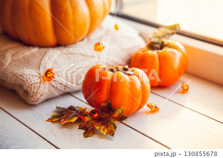 Persimmon on the windowsill with pumpkin, warm wool sweaters and maple leaves Persimmon on the windowsill with pumpkin, warm wool sweaters and maple leaves 130855678