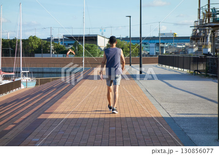 夏の朝の旧堺港の公園で散歩する中年男性の姿 130856077