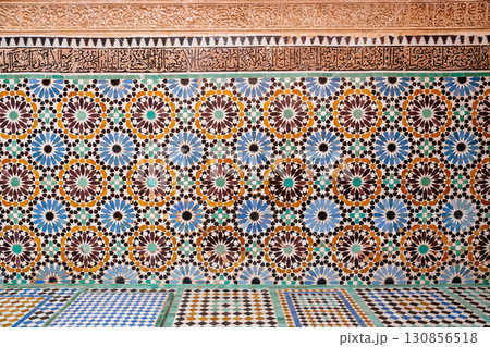 Moroccan zellij tilework showcases intricate geometric patterns and Arabic calligraphy, reflecting rich cultural heritage. 130856518