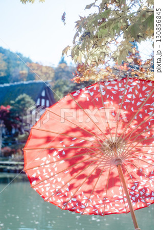 晴れた日の赤い和傘と木漏れ日 130856845