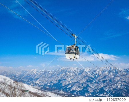 雪山の上空を進むスキー場のゴンドラリフトと冬の絶景 (長野県、白馬、栂池高原) 130857009