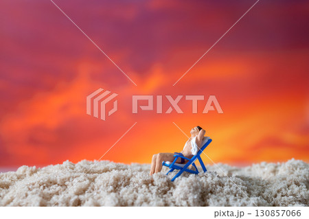 Miniature Man Relaxing on Beach Chair at Sunset Miniature Man Relaxing on Beach Chair at Sunset 130857066