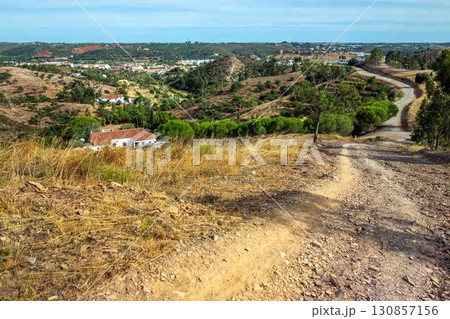 Idyllic landscape with medieval castle seen from dirt path via algarviana hiking trail portugal 130857156